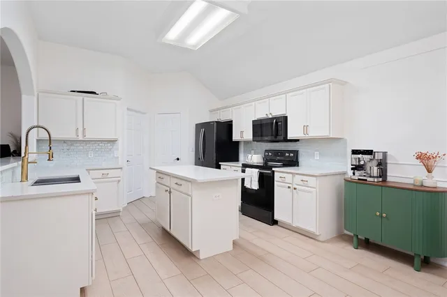 a kitchen with a sink window and stainless steel appliances