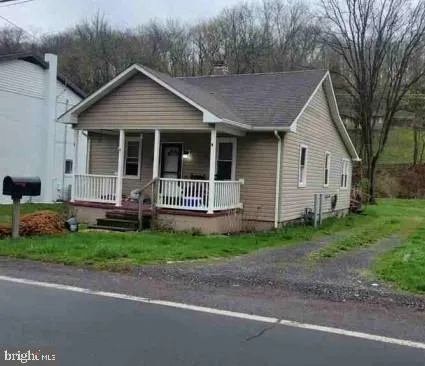 a view of a house with a yard and large tree