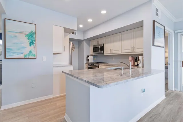 a kitchen with kitchen island sink and refrigerator