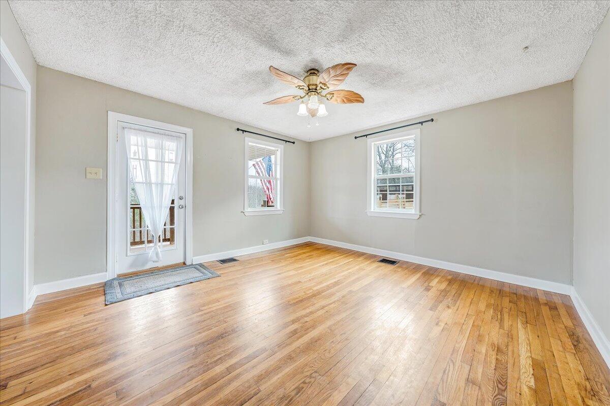 5398 Goodview Road Goodview, VA 24095 - Photo 2 of 59 a view of an empty room with window and wooden floor