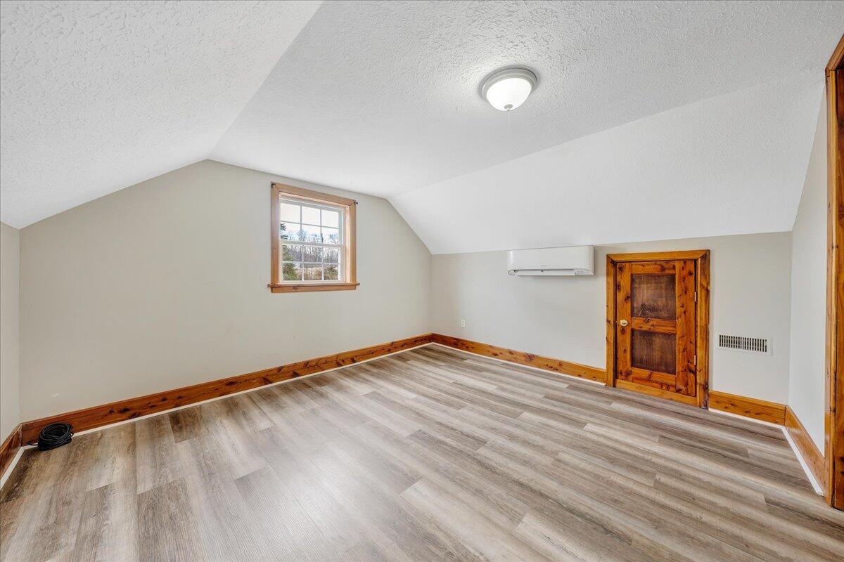 5398 Goodview Road Goodview, VA 24095 - Photo 21 of 59 an empty room with wooden floor and windows