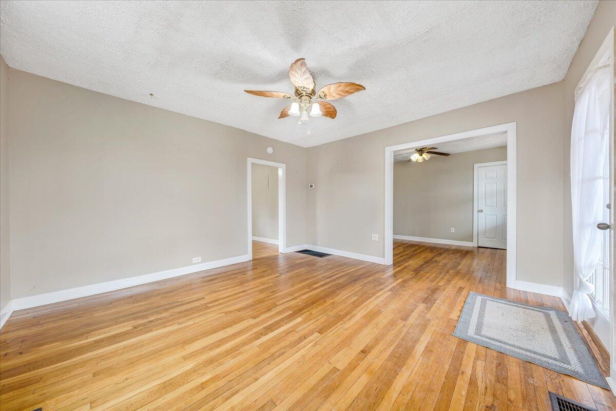 5398 Goodview Road Goodview, VA 24095 - Photo 4 of 59 a view of empty room with wooden floor and fan