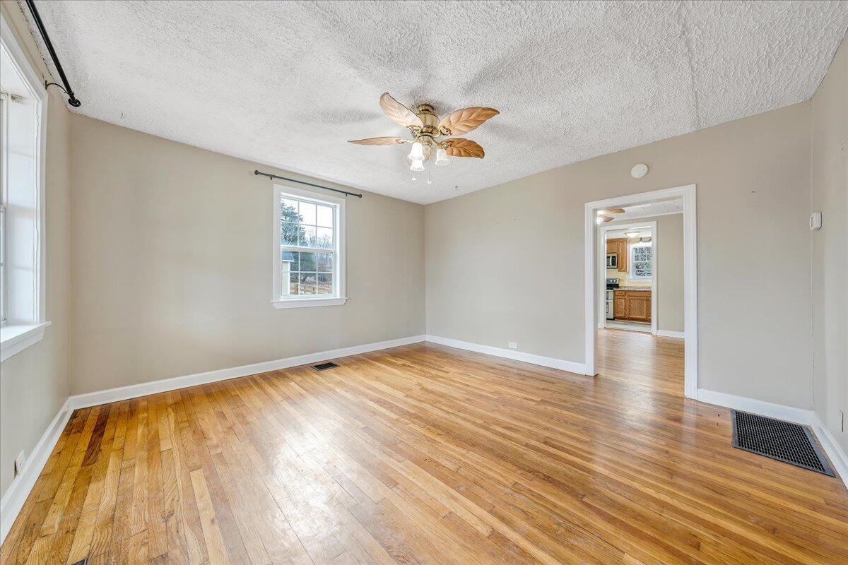 5398 Goodview Road Goodview, VA 24095 - Photo 5 of 59 a view of empty room with wooden floor and fan