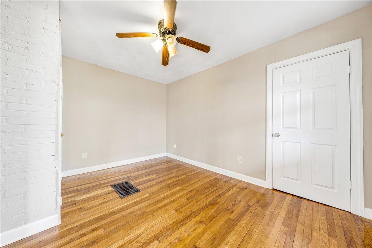 5398 Goodview Road Goodview, VA 24095 - Photo 6 of 59 an empty room with wooden floor fan and windows