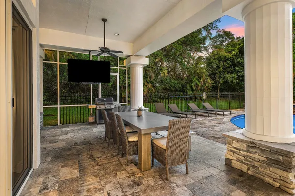 a view of swimming pool with lawn chairs and plants