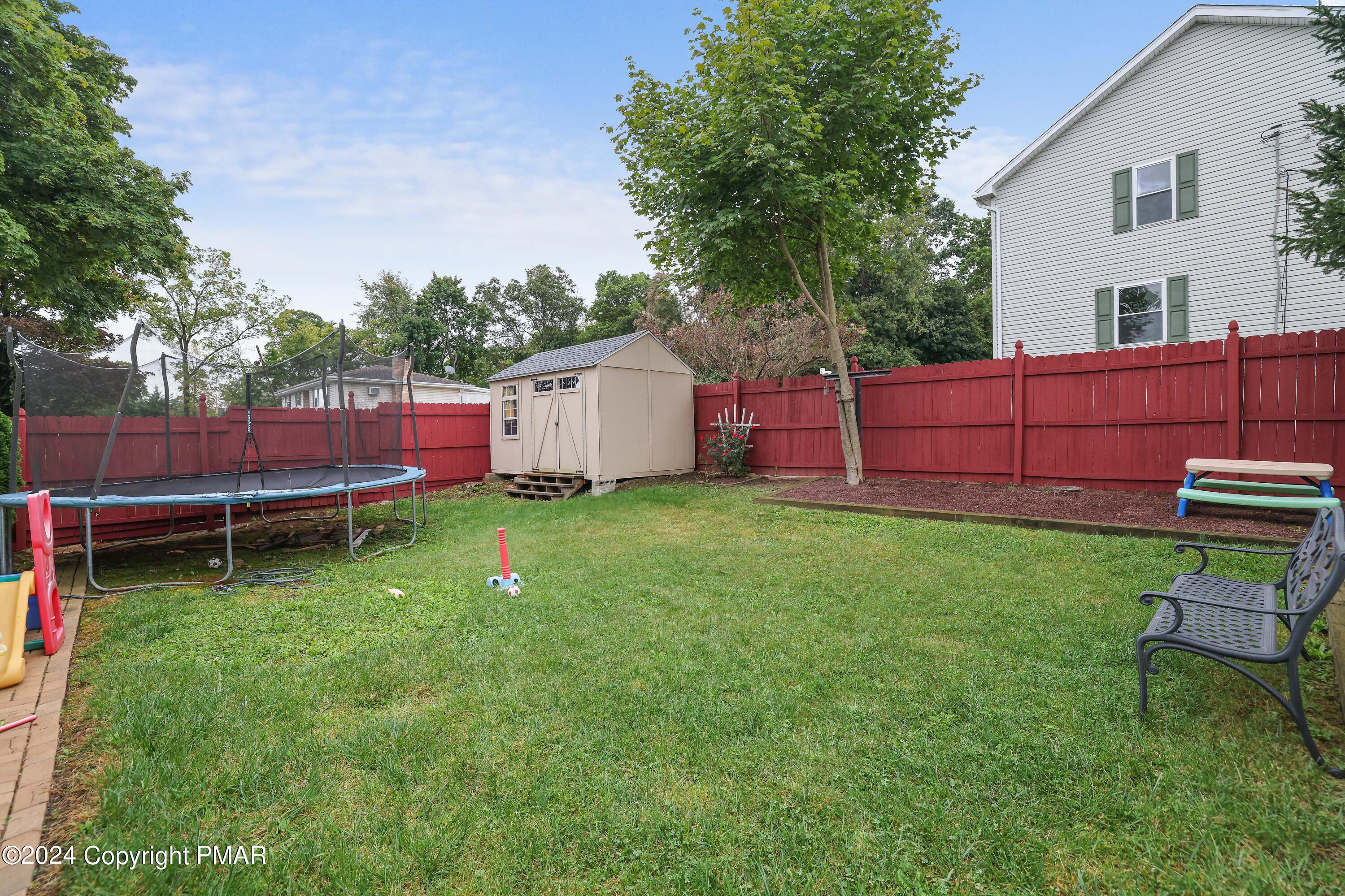 9 Jewel Street Roseto, PA 18013 - Photo 19 of 23 a backyard of a house with wooden fence and large trees