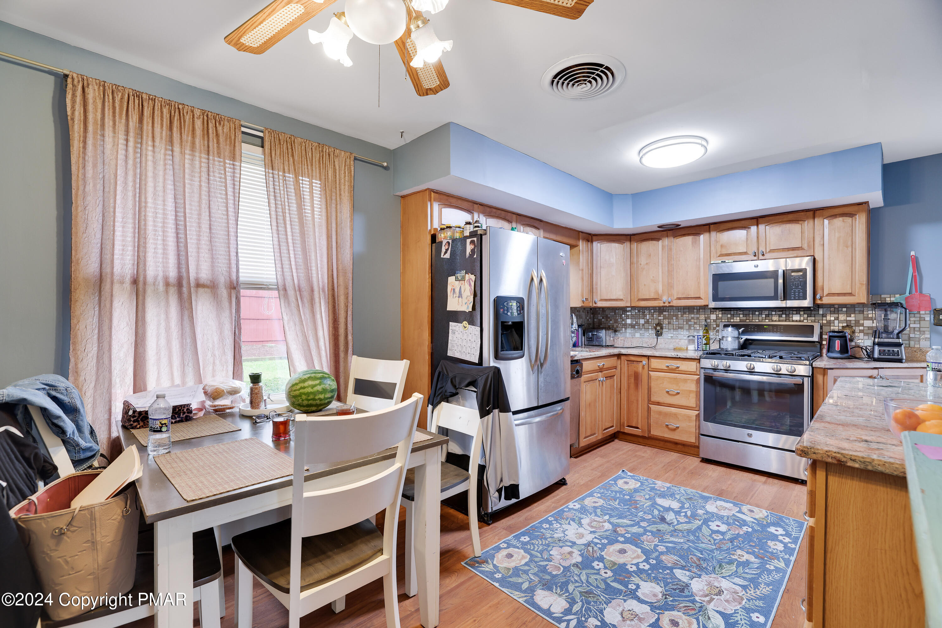 9 Jewel Street Roseto, PA 18013 - Photo 5 of 23 a kitchen with stainless steel appliances granite countertop a refrigerator a sink dishwasher a stove and a dining table with wooden floor