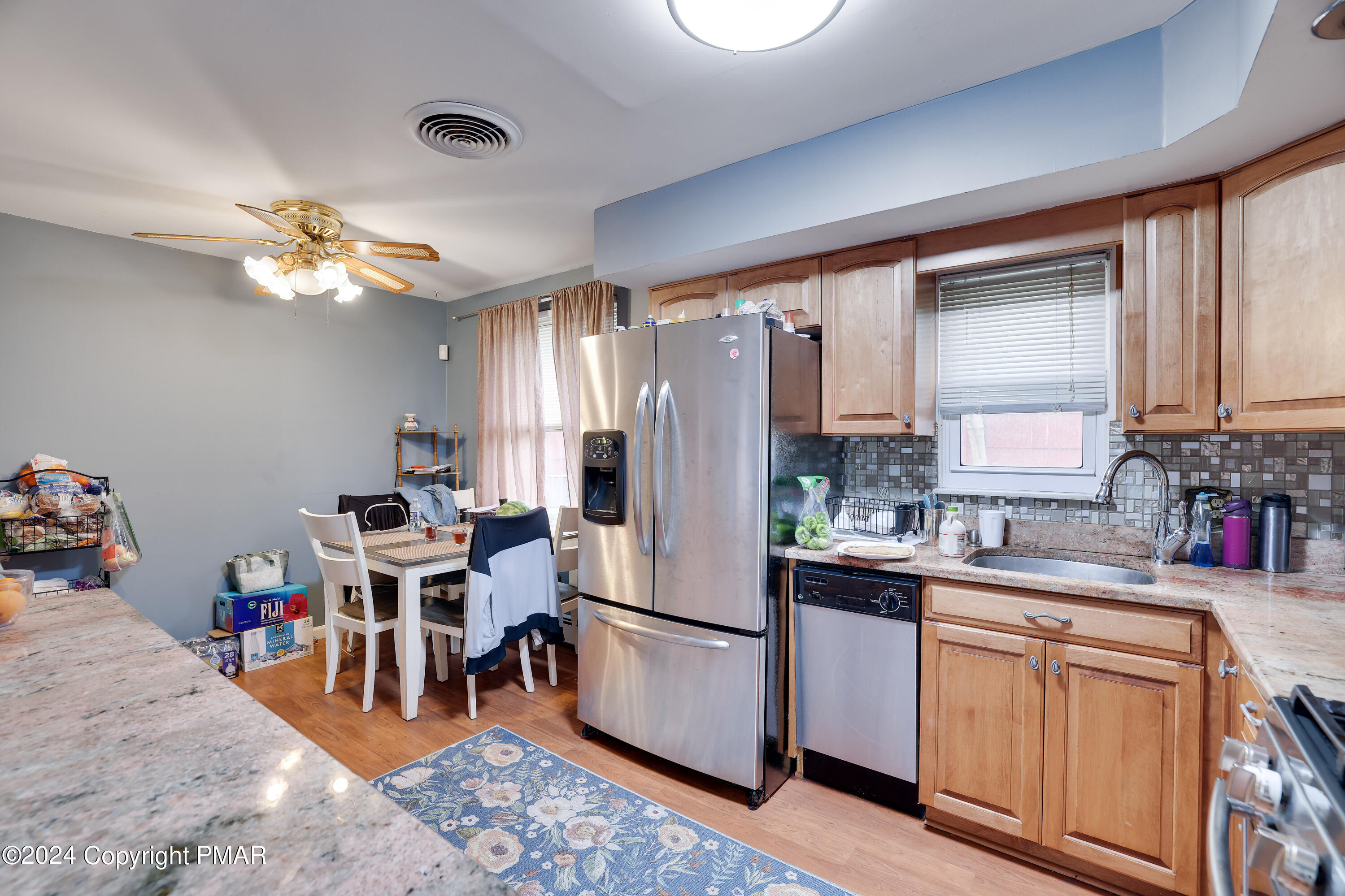 9 Jewel Street Roseto, PA 18013 - Photo 7 of 23 a kitchen with stainless steel appliances granite countertop a refrigerator a sink dishwasher a dining table and chairs with wooden floor