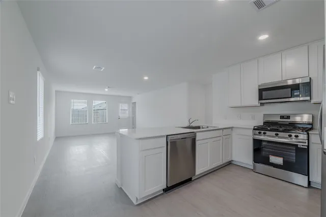 a kitchen with stainless steel appliances granite countertop a stove and a sink