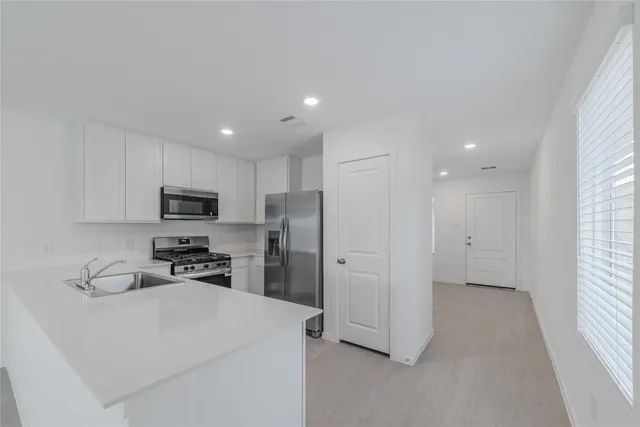 a view of kitchen with stainless steel appliances refrigerator oven and cabinets