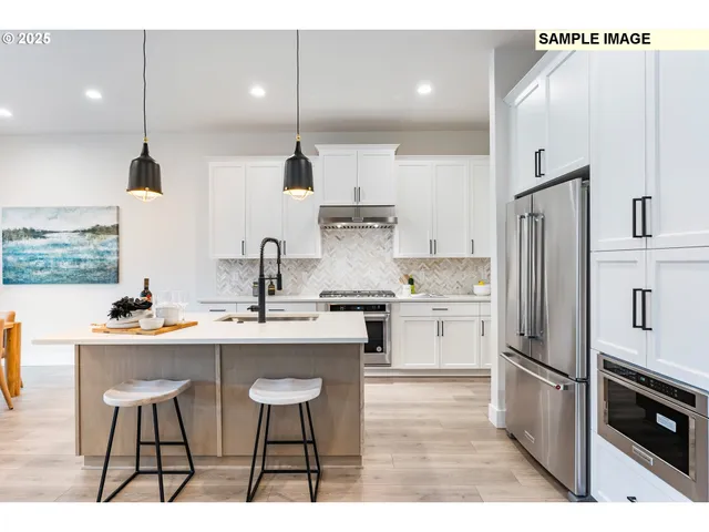 a kitchen with stainless steel appliances granite countertop a sink a stove and a wooden floors