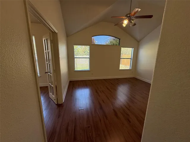 a view of empty room with wooden floor