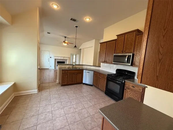 a kitchen with stainless steel appliances granite countertop a refrigerator sink and stove