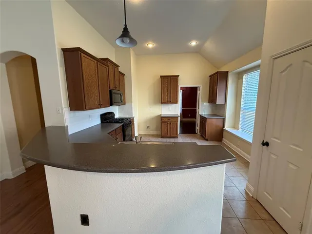 a kitchen with stainless steel appliances granite countertop a refrigerator a stove and a sink