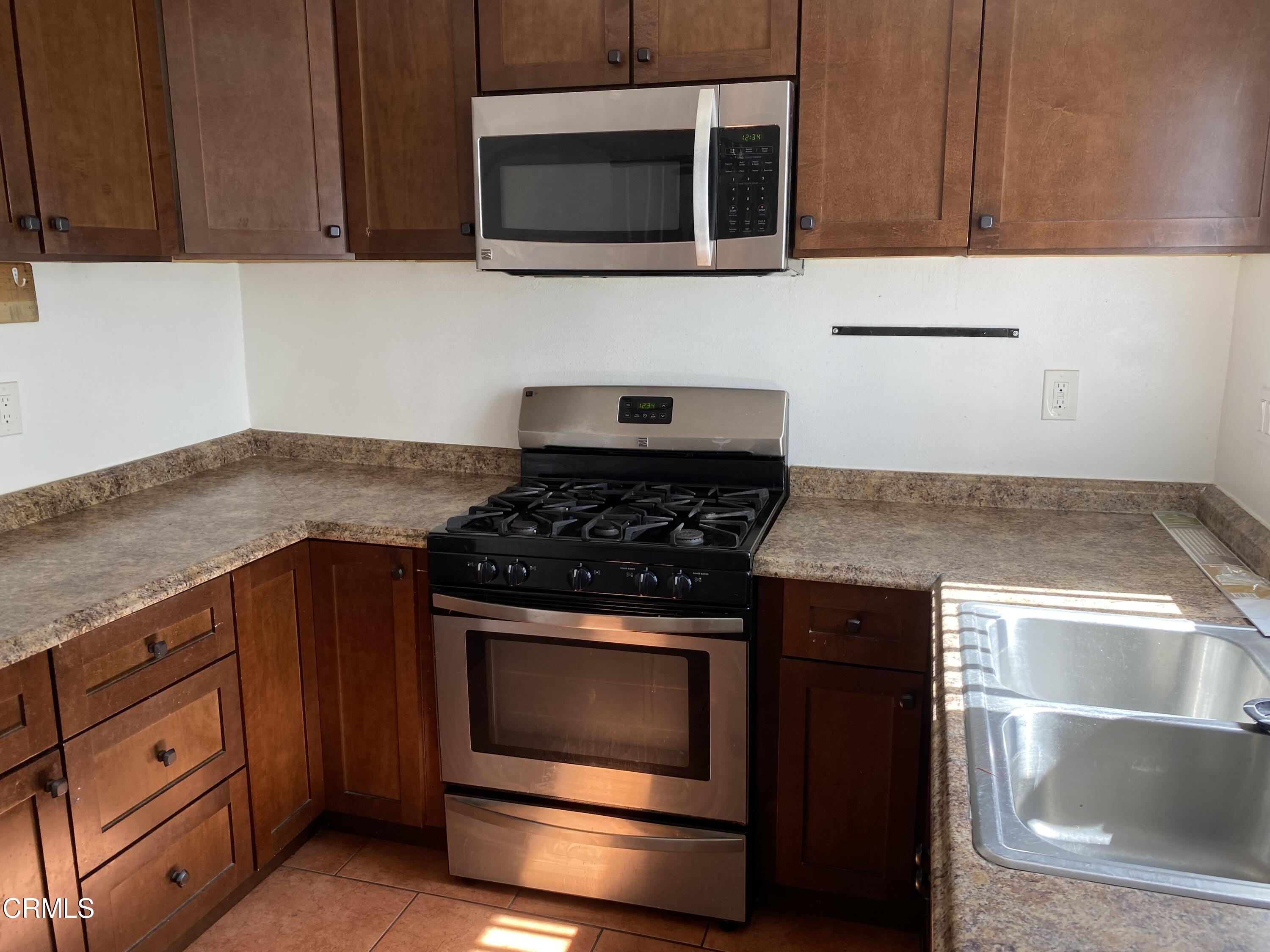 5305 Perkins Road Oxnard, CA 93033 - Photo 6 of 23 a kitchen with granite countertop cabinets stainless steel appliances and wooden cabinets
