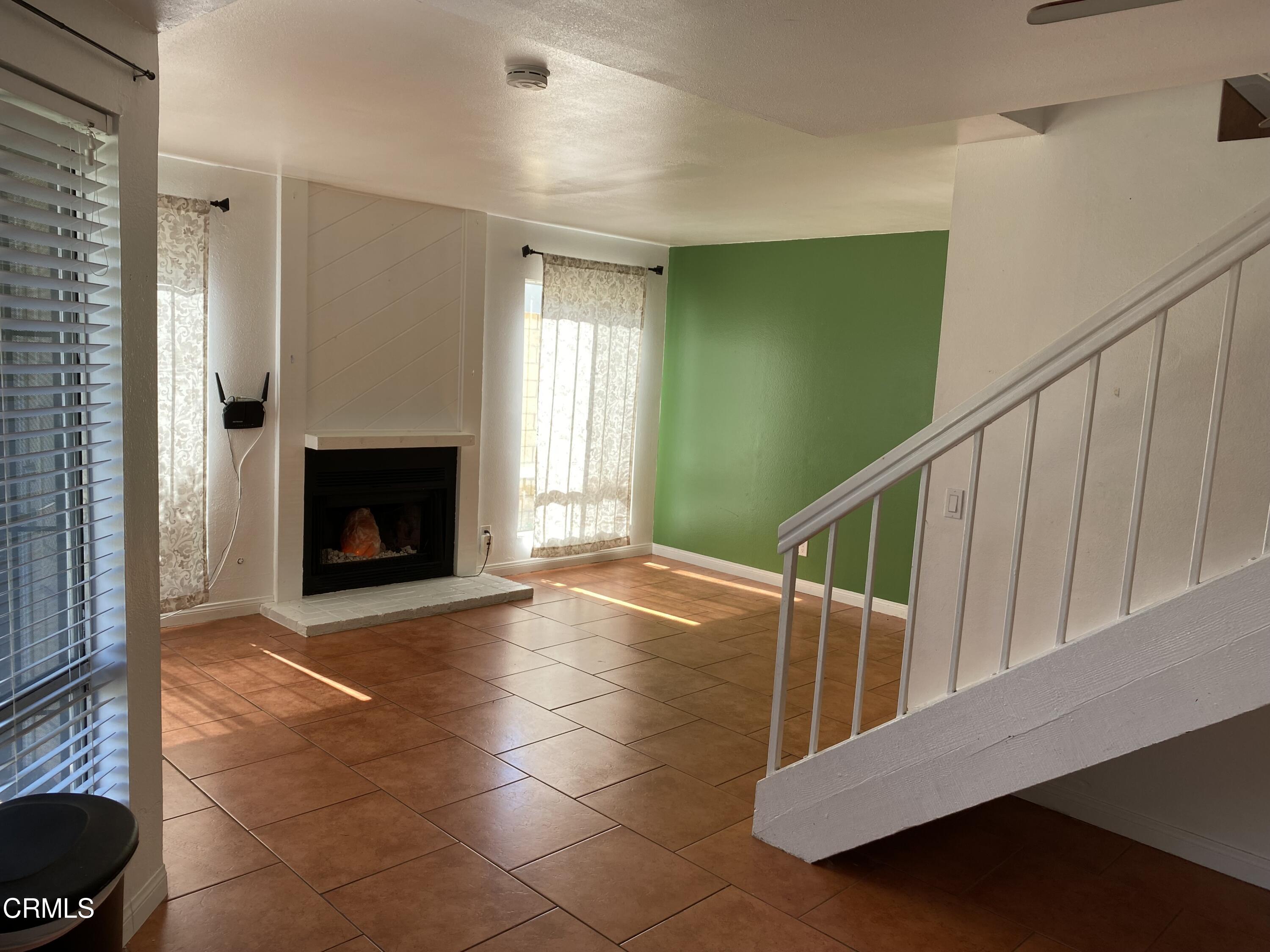 5305 Perkins Road Oxnard, CA 93033 - Photo 9 of 23 a view of an empty room with a fireplace and a window