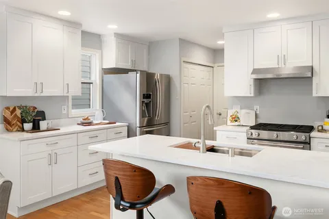 a kitchen with stainless steel appliances a stove a sink a refrigerator and cabinets