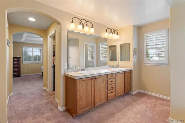 a spacious bathroom with a granite countertop sink and a mirror