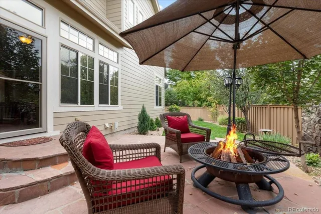 a view of a patio with couches chairs and a umbrella