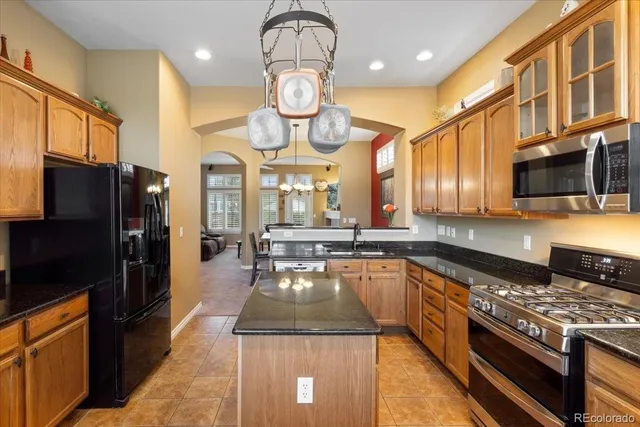 a kitchen with stainless steel appliances granite countertop a stove refrigerator and cabinets