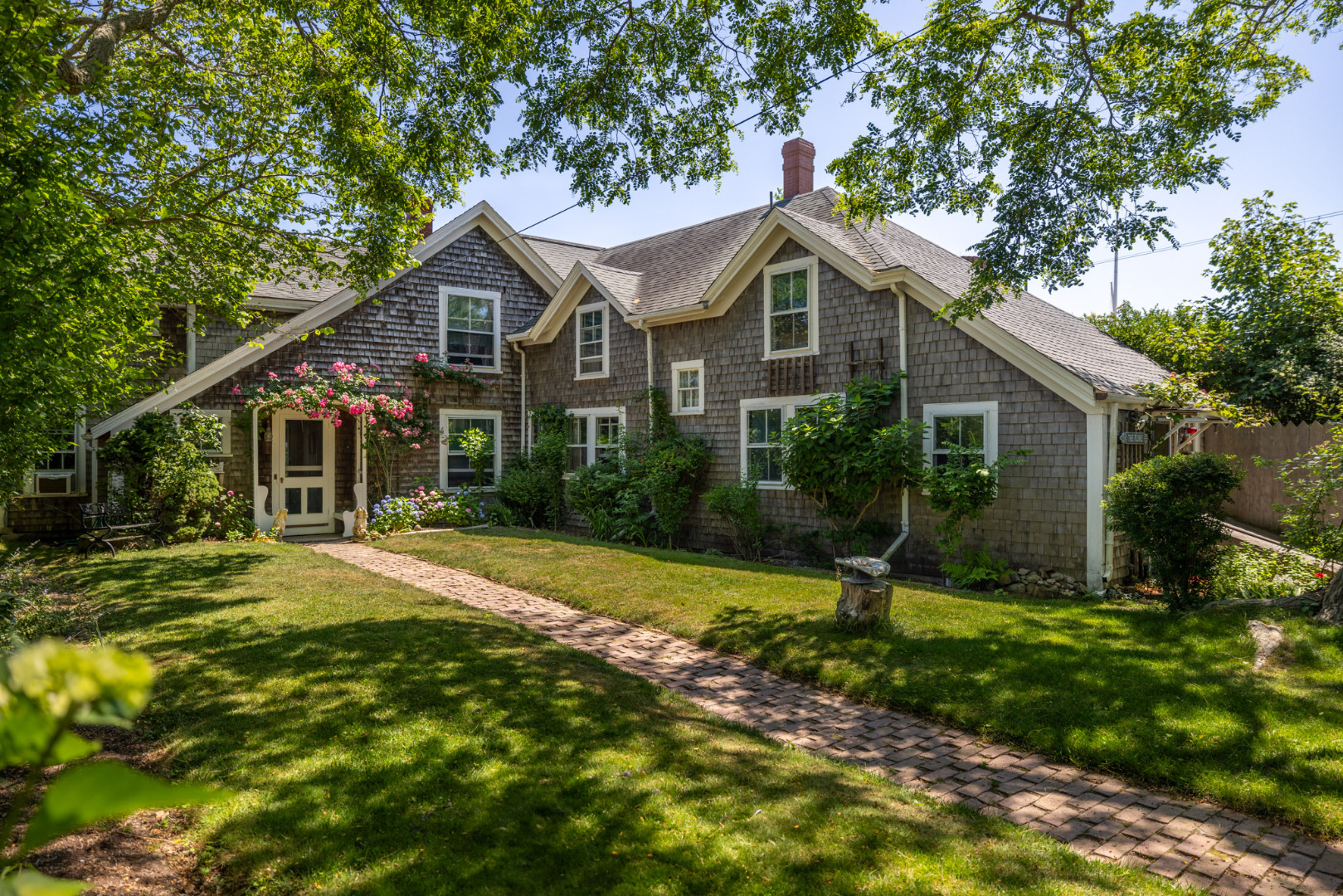 13 Cliff Road Nantucket, MA 02554 - Photo 2 of 38 a front view of a house with a yard and trees