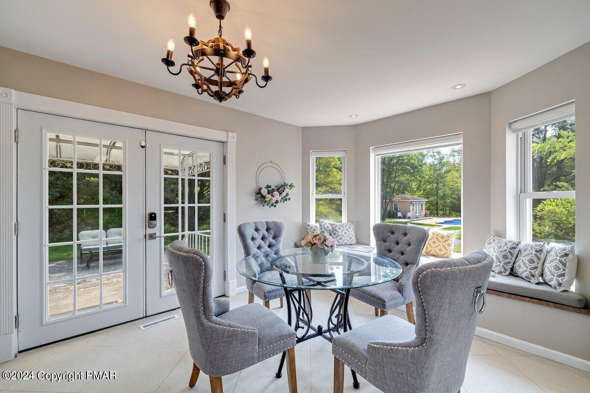 2175 Longview Drive Bushkill, PA 18324 - Photo 11 of 50 a dining room with furniture a potted plant and a chandelier