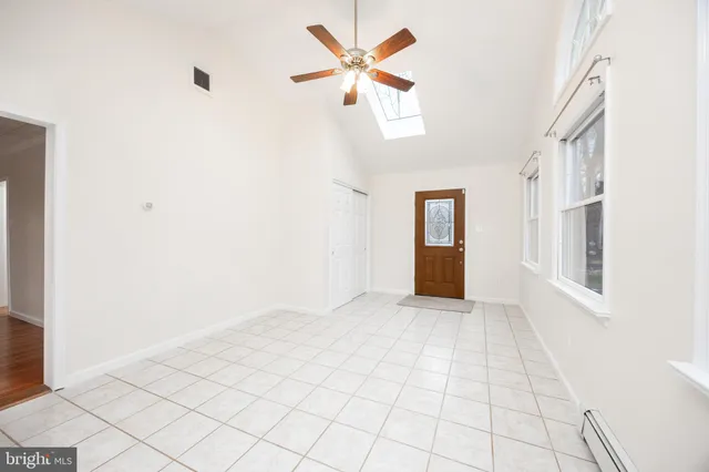 an empty room with windows and ceiling fan