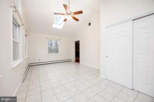 an empty room with windows and fan