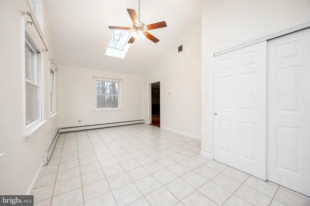 an empty room with windows and fan