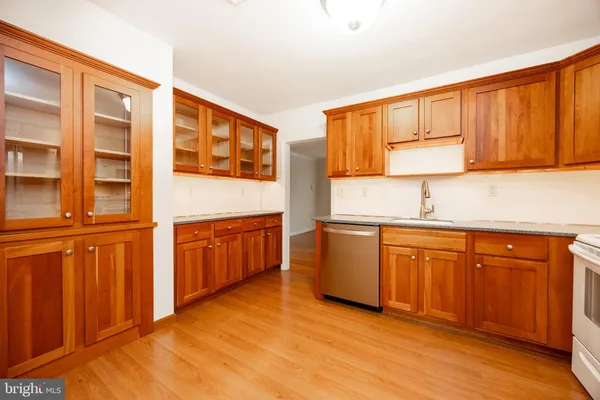 a kitchen with stainless steel appliances granite countertop a stove a sink and a refrigerator with wooden cabinets