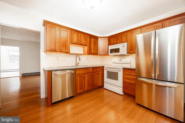 a kitchen with stainless steel appliances granite countertop a refrigerator a stove top oven a sink and dishwasher
