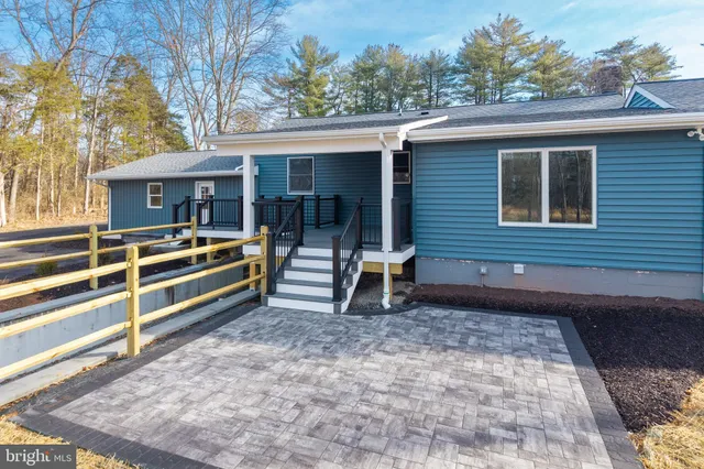 a front view of house with yard and trees in the background