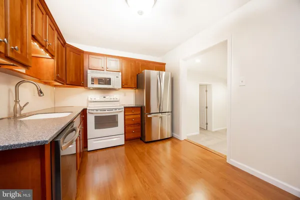 a kitchen with stainless steel appliances granite countertop a refrigerator a stove and a sink