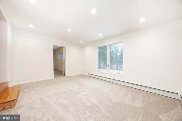 a view of empty room with wooden floor and fireplace