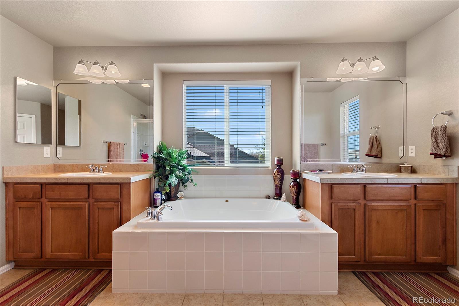 8151 Raspberry Drive Frederick, CO 80504 - Photo 23 of 35 a spacious bathroom with sink shower and mirror