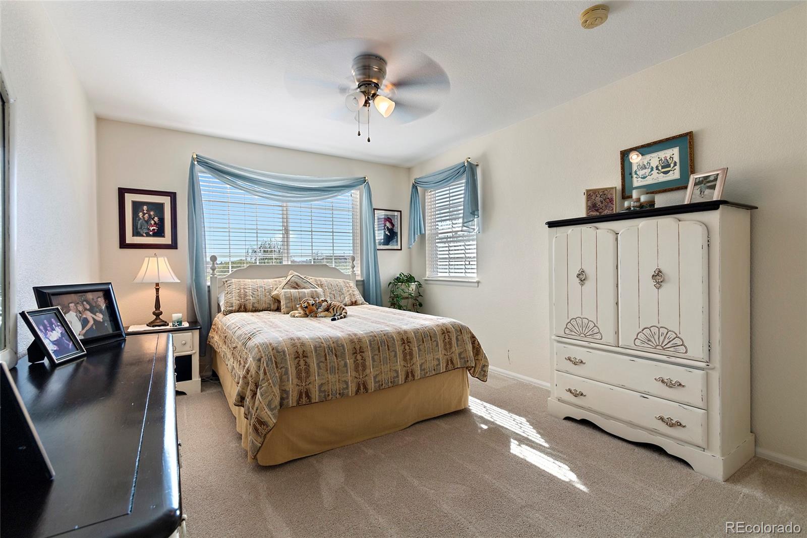 8151 Raspberry Drive Frederick, CO 80504 - Photo 25 of 35 a spacious bedroom with a bed a couch and dresser