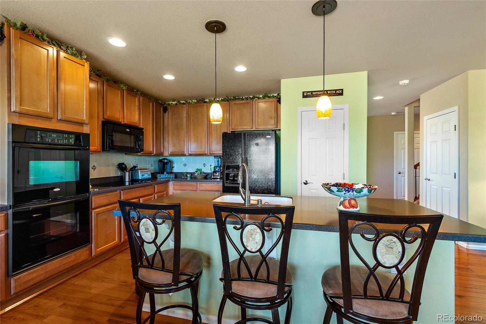 8151 Raspberry Drive Frederick, CO 80504 - Photo 8 of 35 a dining room with stainless steel appliances kitchen island granite countertop a dining table chairs refrigerator and a sink
