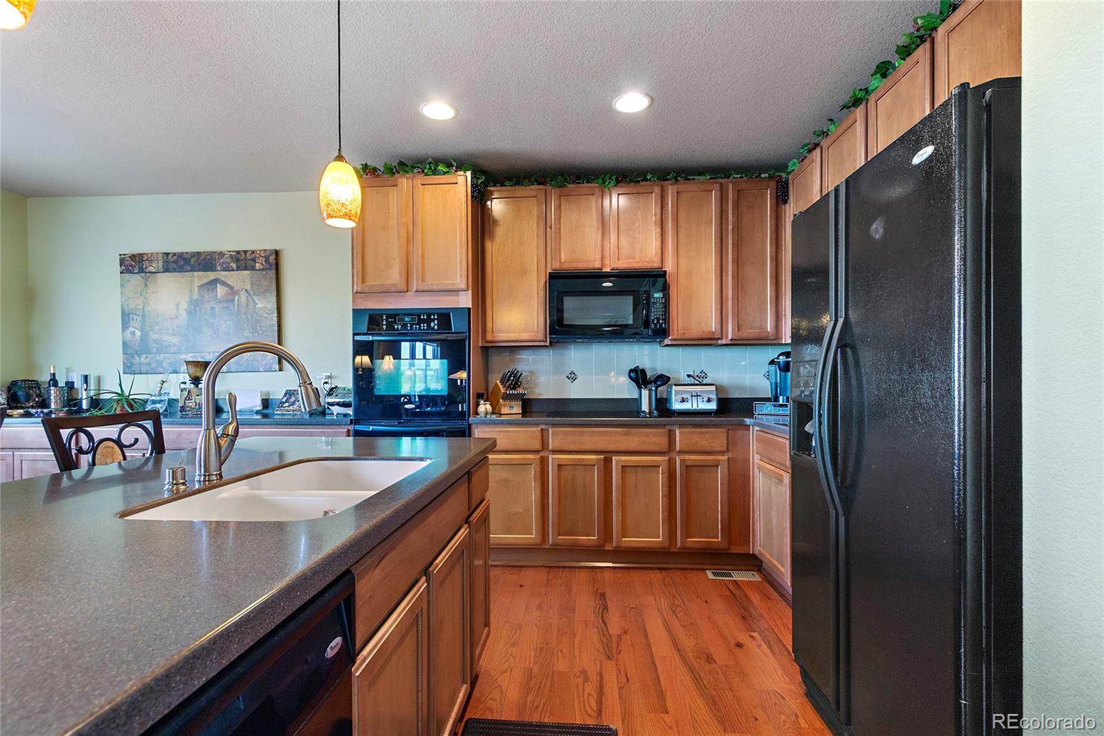 8151 Raspberry Drive Frederick, CO 80504 - Photo 10 of 35 a kitchen with stainless steel appliances granite countertop a sink refrigerator and cabinets