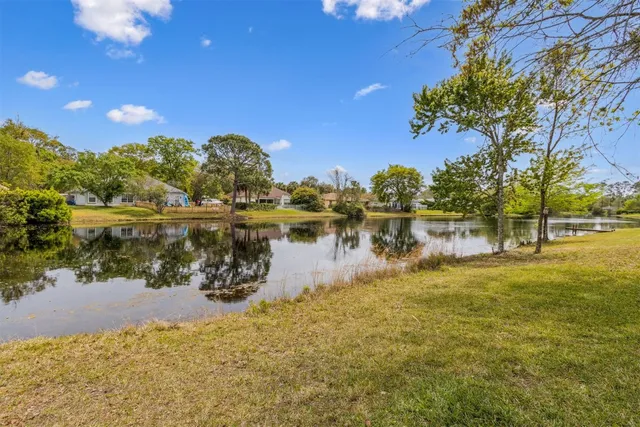 a view of a lake with a yard and trees