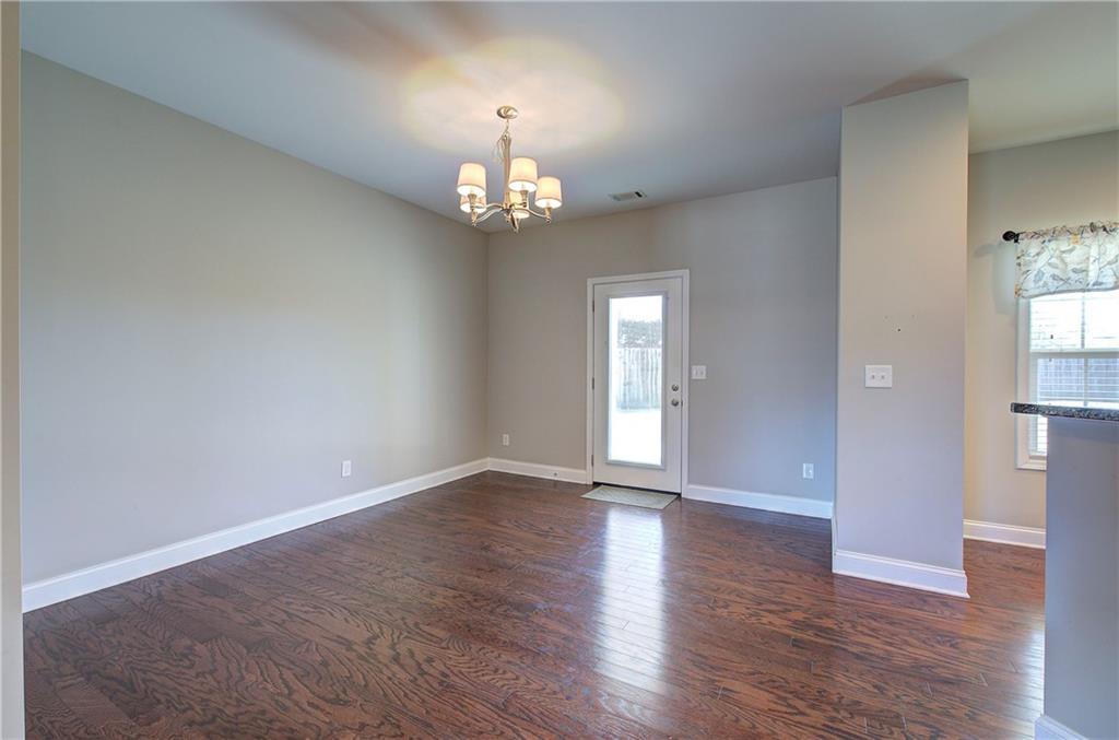 25 Winter Pointe Northwest Cartersville, GA 30121 - Photo 9 of 43 an empty room with wooden floor chandelier and windows