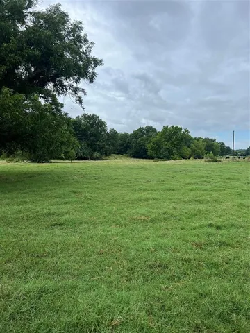 a view of a field with an trees in the background