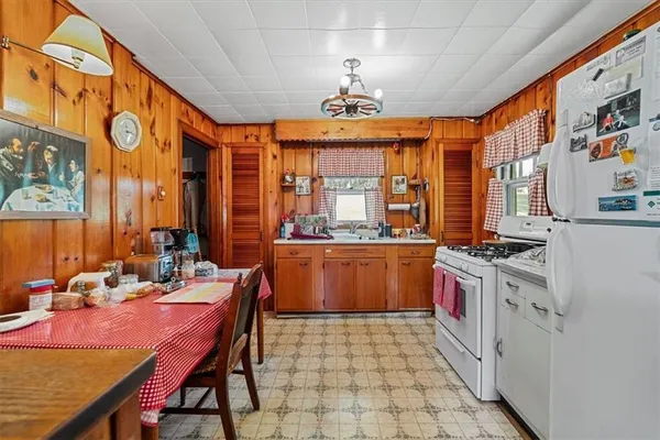 a open kitchen with stainless steel appliances granite countertop a stove top oven a refrigerator and a dining table with the kitchen view