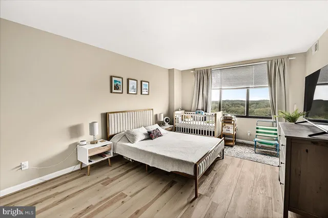 a bedroom with a bed and a large window