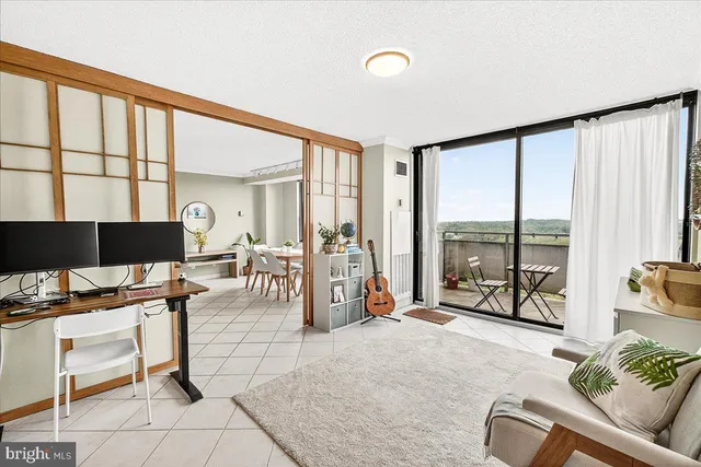 a living room with furniture a flat screen tv and a large window