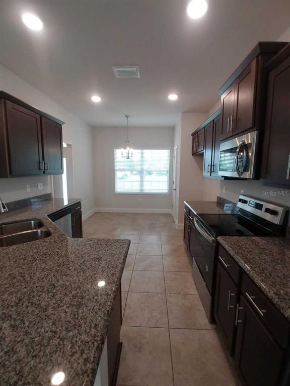 4380 Southwest 92nd Pl Road Ocala, FL 34476 - Photo 6 of 57 a kitchen with stainless steel appliances granite countertop a sink stove and refrigerator