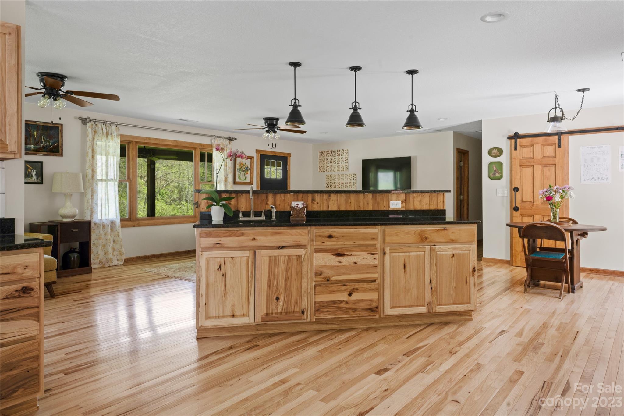241 Sandy Mush Road Marshall, NC 28753 - Photo 18 of 46 a kitchen with stainless steel appliances granite countertop a stove and white cabinets with wooden floor