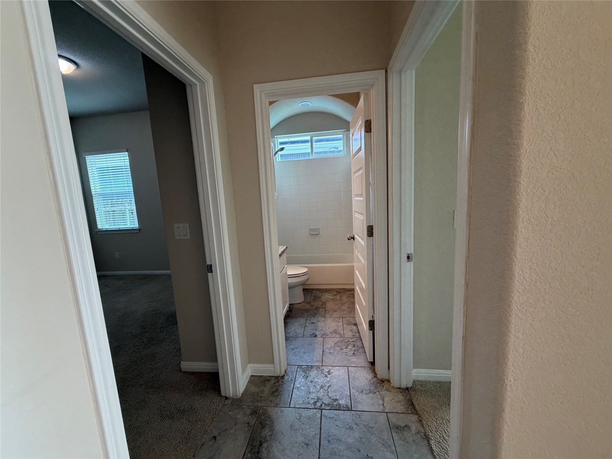 419 Gettysburg Loop Elgin, TX 78621 - Photo 17 of 21 A well-lit hallway connects inviting rooms, each with distinct flooring, creating a comfortable flow.