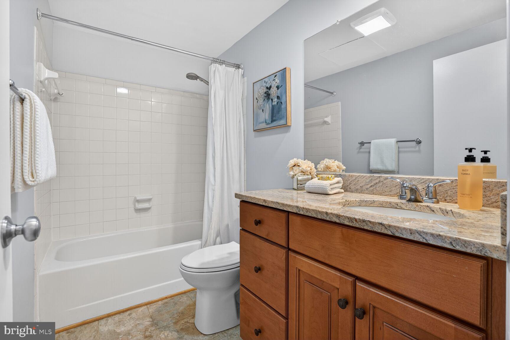 11116 Beaver Trail Court, Unit 11116 Reston, VA 20191 - Photo 26 of 28 a bathroom with a granite countertop sink a toilet and a bathtub