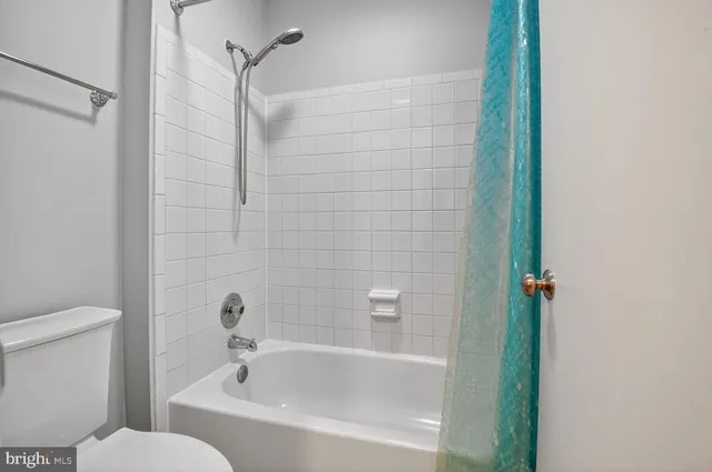 a bedroom with a bed and a flat tv screen on dresser