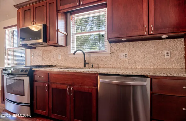 a kitchen with stainless steel appliances granite countertop a sink stove and cabinets